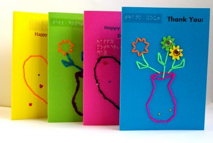 Four display of portrait style tactile scented Brailled greetings cards in multiple bright colours
