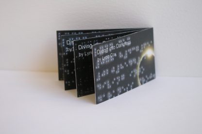 fan display of 4 Brailled business cards on white plinth